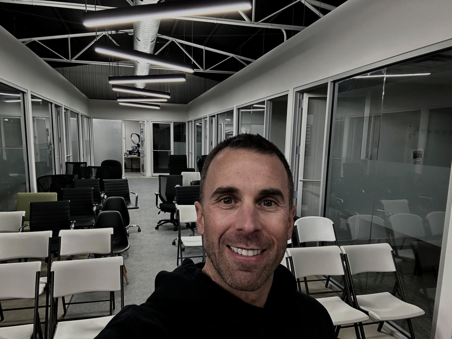 Tony LeBlanc in the corridor of the property management office in Moncton, rows of chairs set out behind him for an event.