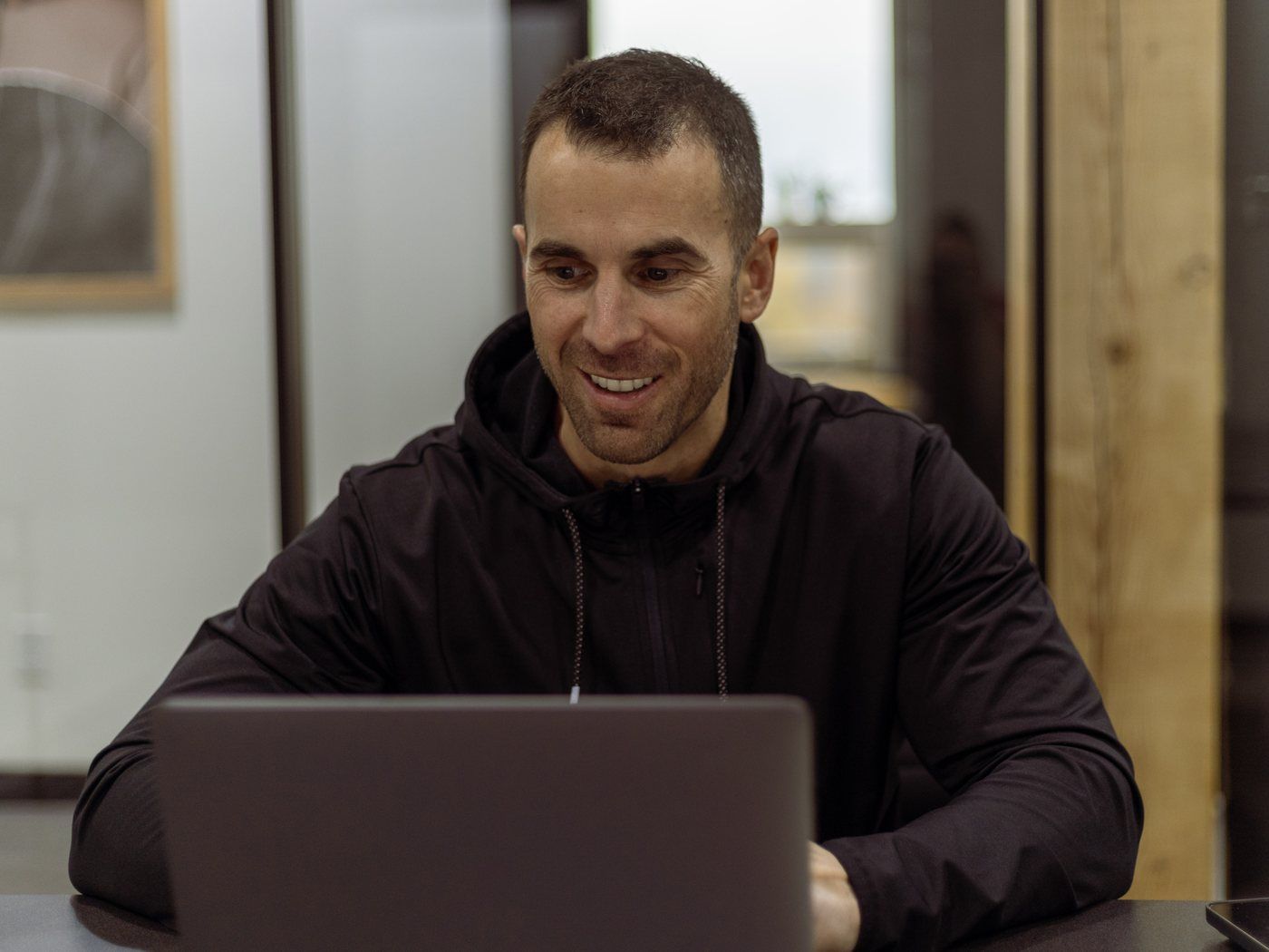 Tony at his laptop in the office, smiling